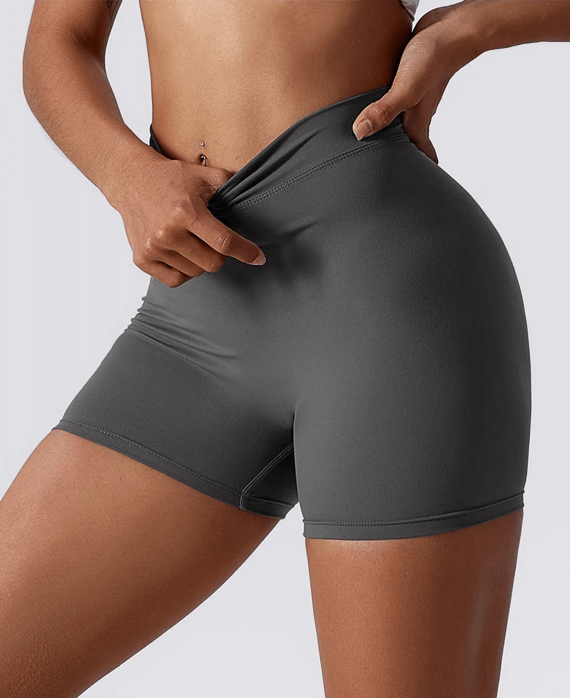 Woman wearing gray elastic performance yoga shorts, perfect for active wear, yoga, and sports, ensuring flexibility and comfort.